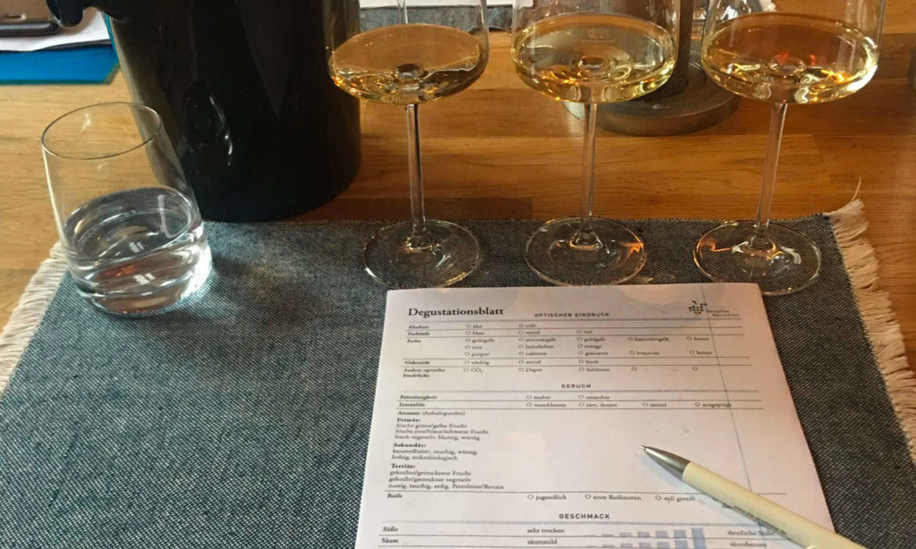 Weingläser mit degustierten  Weinen sowie Verkostungsbogen, wie er auch bei Weinproben, Seminare & Co. von sensationWein im Format "Family and Friends" benutzt wird