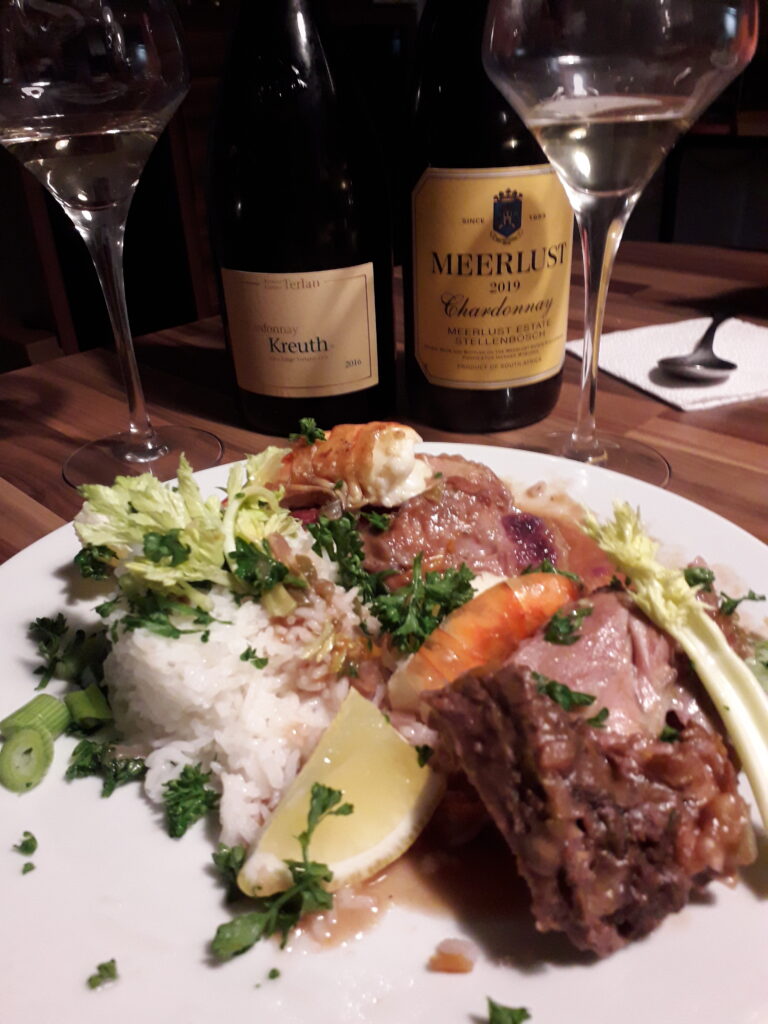 Foto eines kreolisches Gericht mit dem Chardonnay von Meerlust und dem Chardonnay Kreuth aus Terlan als Weinbegleitung