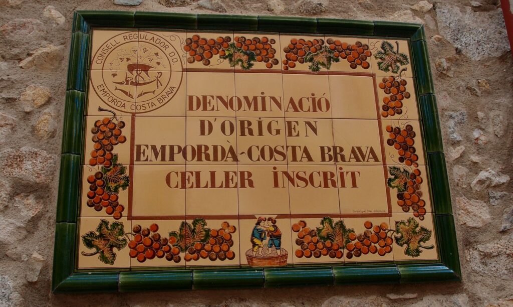 Schild mit der alten D.O.-Bezeichnung Empordà-Costa Brava am Gebude des Weingutes Oliveda in Capmany.